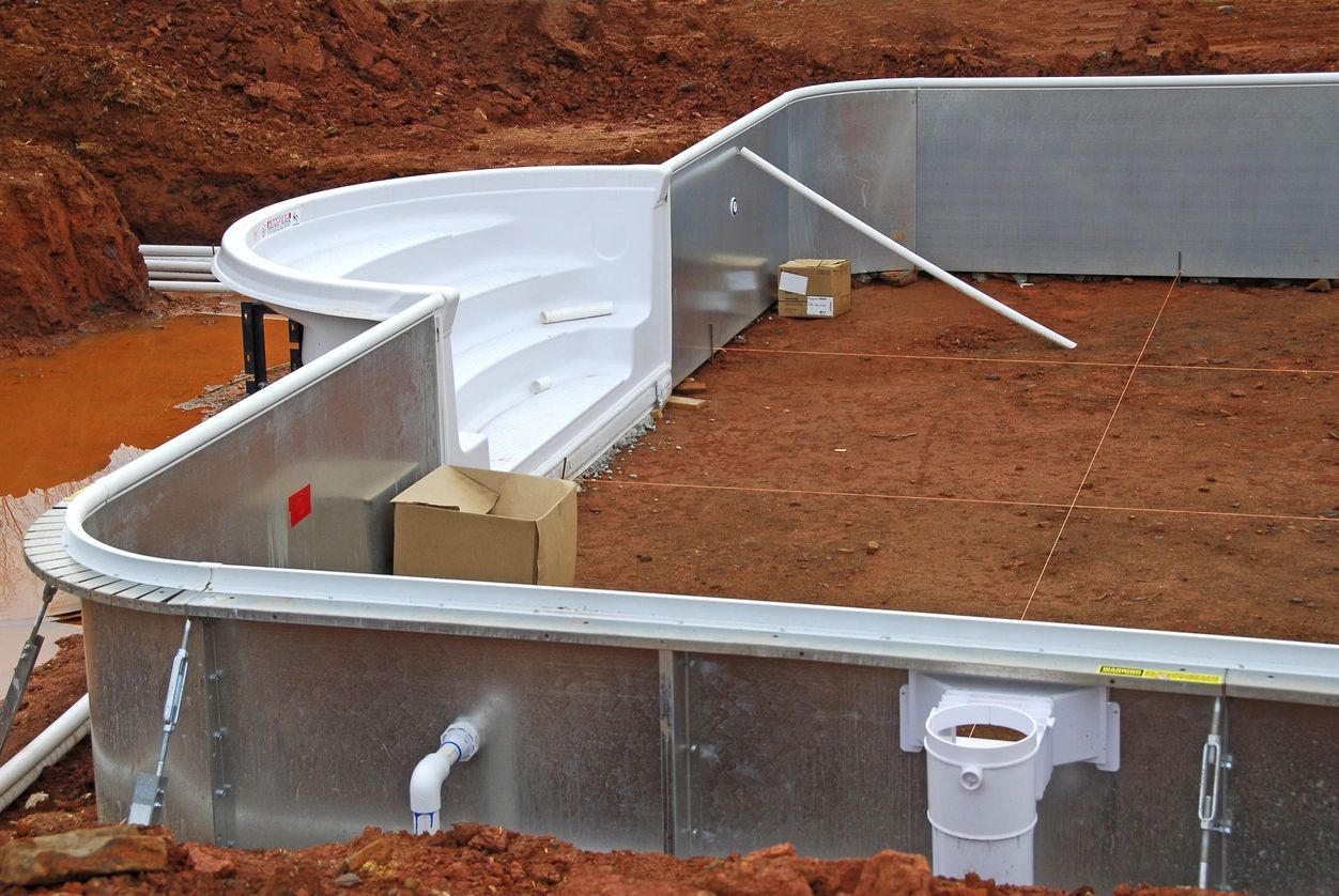 A view of the inside of a pool with sand and pipes.